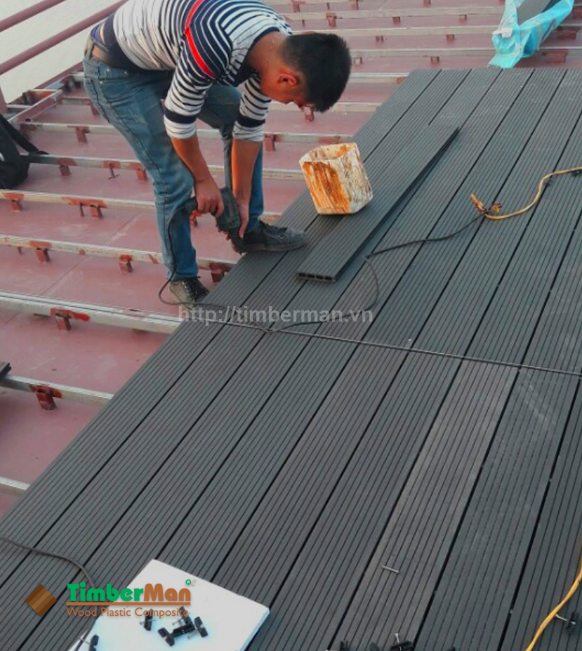 Một thợ thi công đang lắp đặt sàn gỗ ngoài trời timberman trên sàn tàu biển ngoài trời